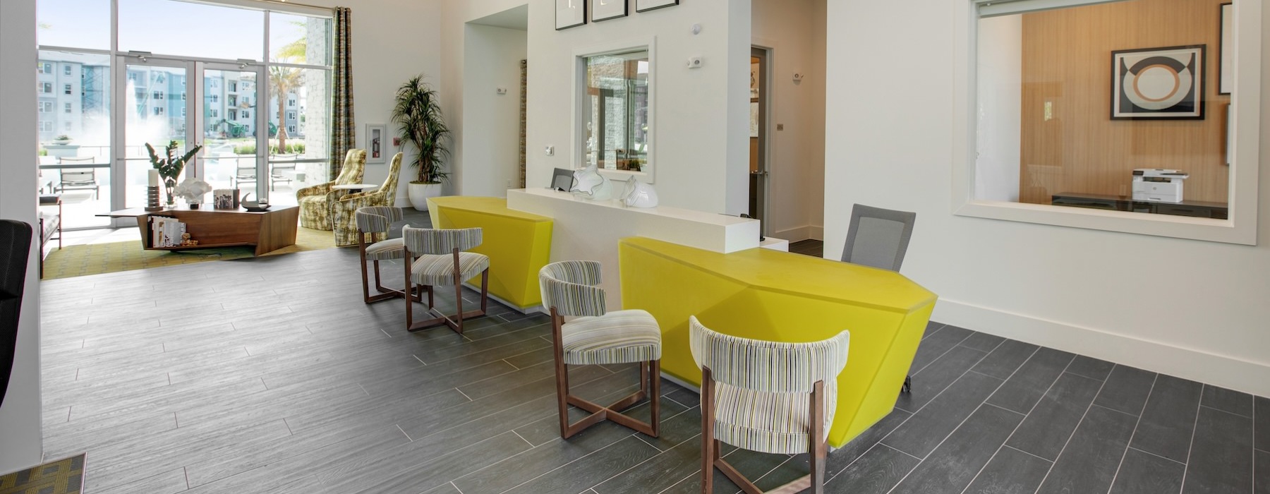 a leasing office with a front desk, tables and chairs